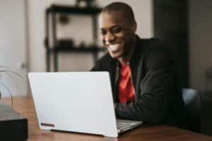 Man Smiling While Working on Laptop